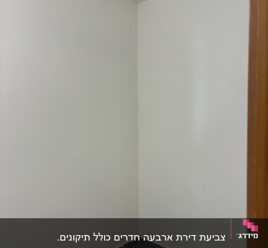 קיר צבוע בלבן עם רצפת אריחים אפורה